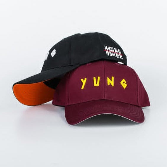 Two YUNG baseball caps, one black and orange, the other maroon with 'YUNG' embroidered in yellow, on a white background.
South Africa