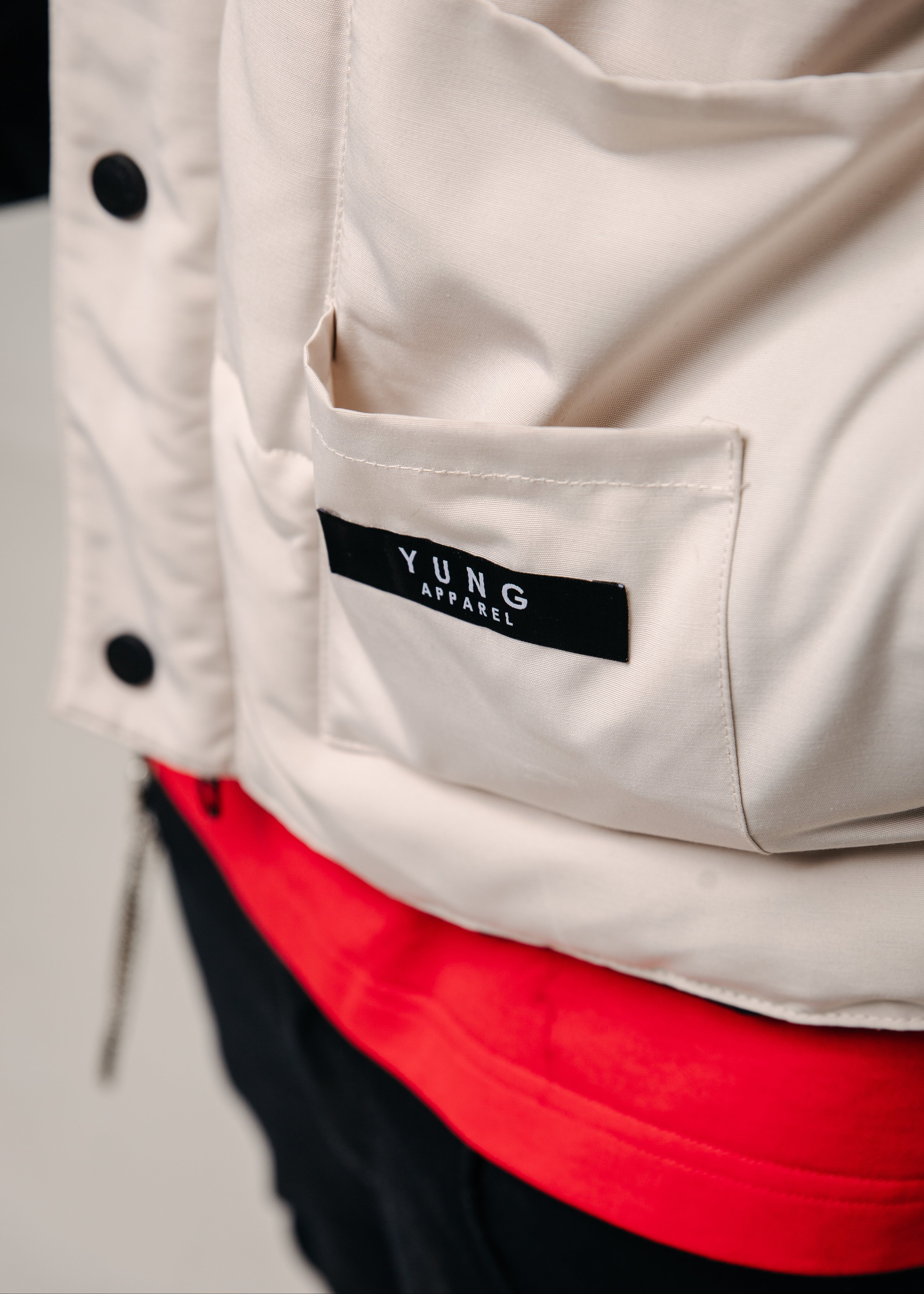 Close-up of a beige jacket with a 'YUNG' label on a neutral background
South Africa