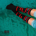 YUNG Black and red striped socks with visible branding on a textured green background
Streetwear South Africa