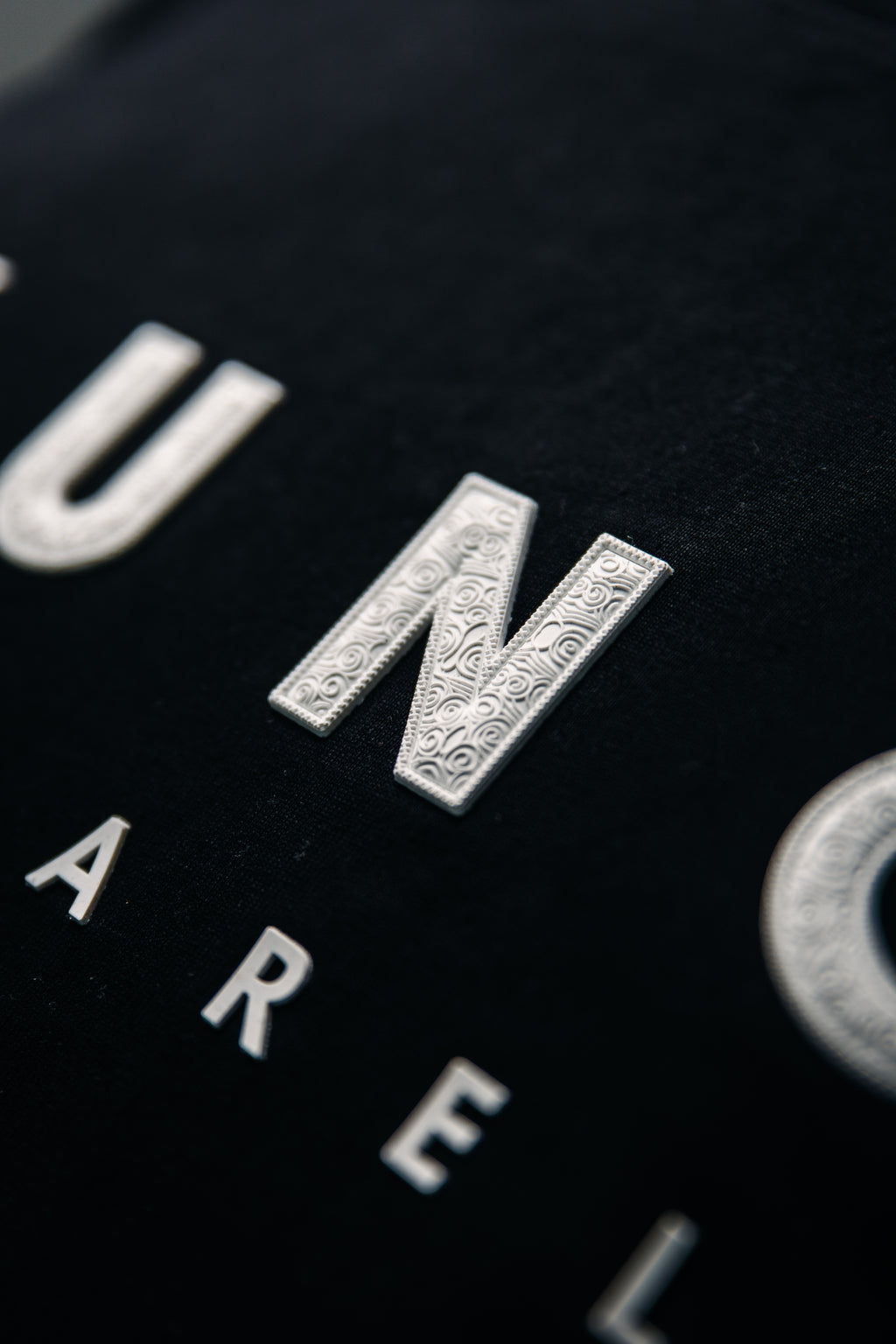 Close-up of a YUNG black garment with white text and logos.
South Africa
