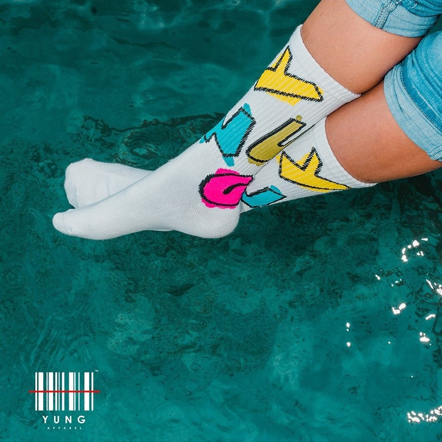 Person wearing colorful socks with 'YUNG' branding by a pool.
South Africa