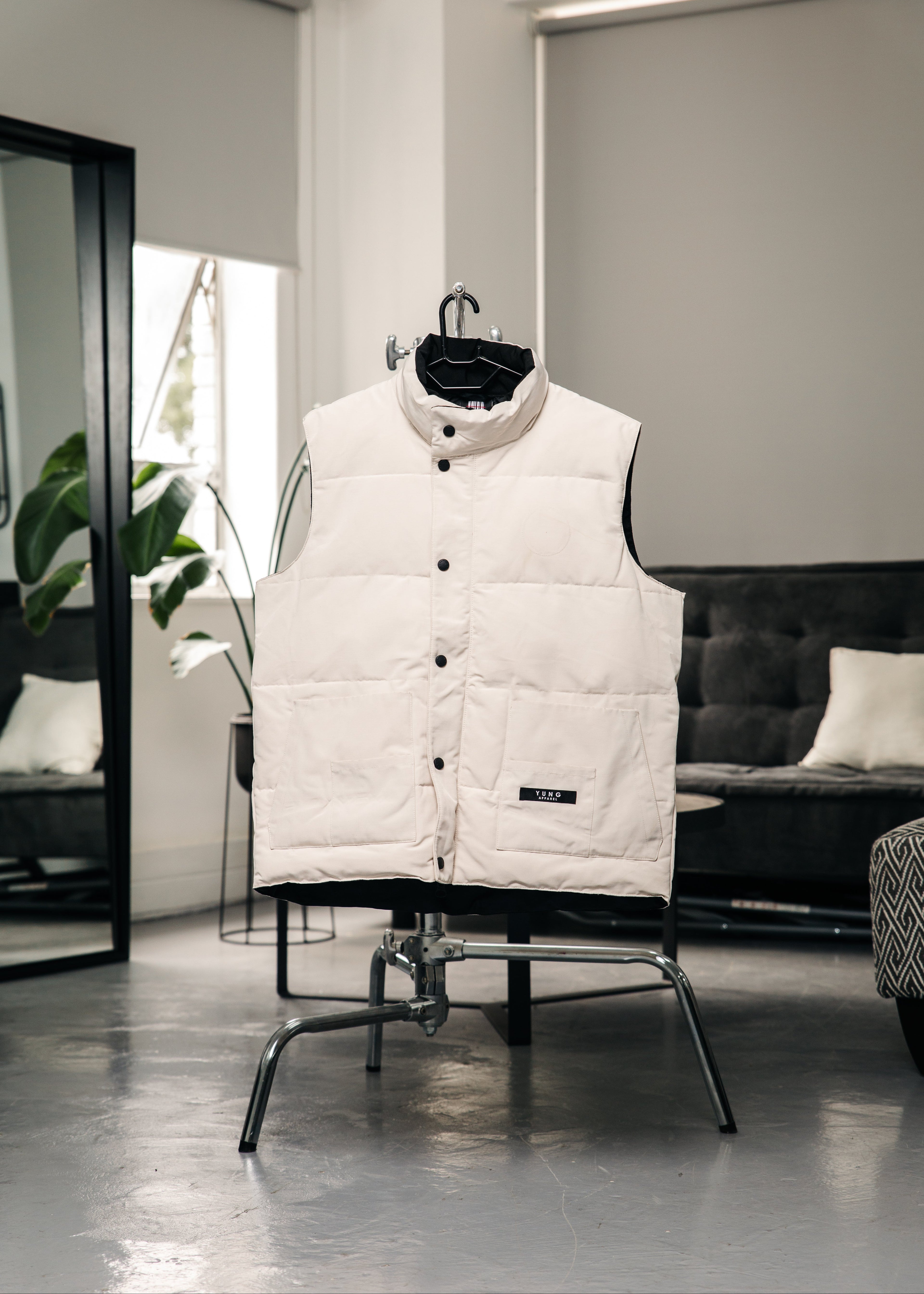 YUNG White puffer vest on a chair in a modern room with a sofa and plant.
South Africa