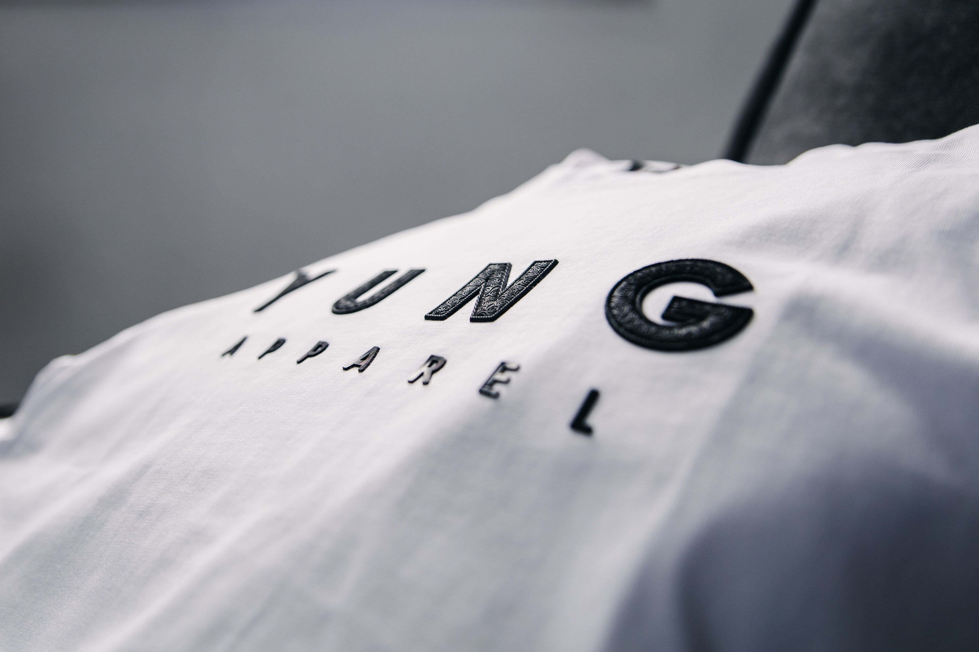 Close-up of a white shirt with 'Yung' branding on a t-shirt
South Africa