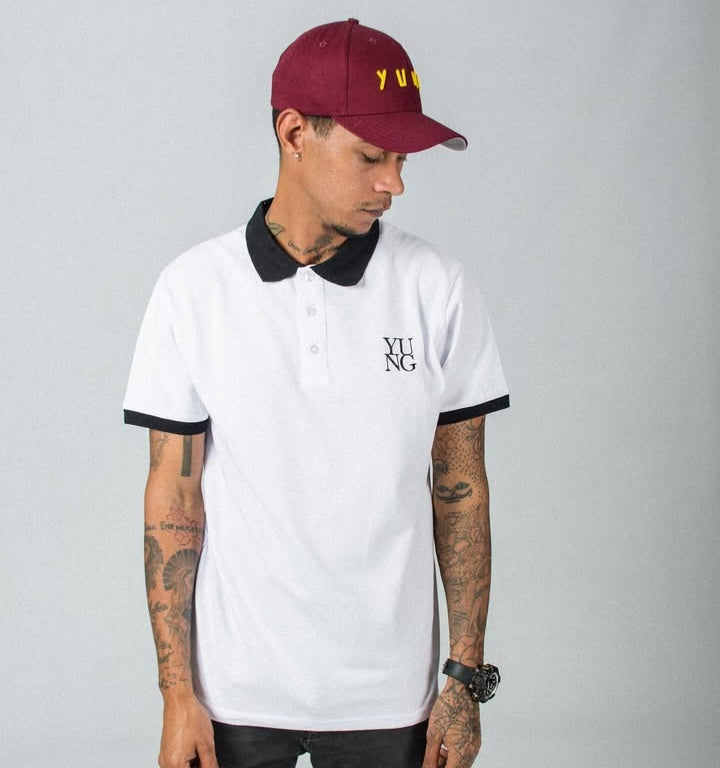 Person wearing a YUNG white golf shirt with black trim and a YUNG maroon baseball cap on a gray background
South Africa
