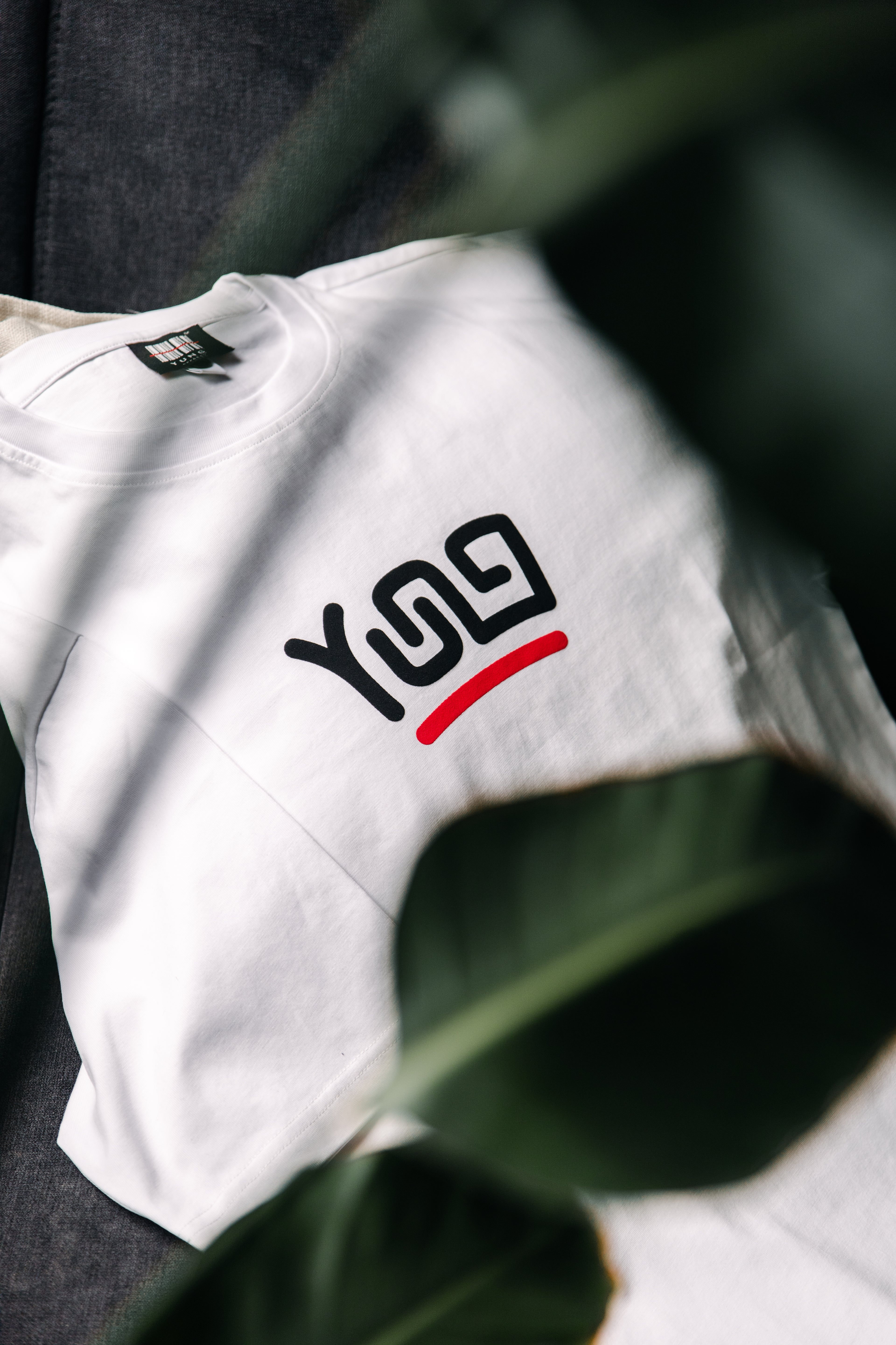 YUNG White t-shirt with black and red logo on a blurred background
Streetwear South Africa