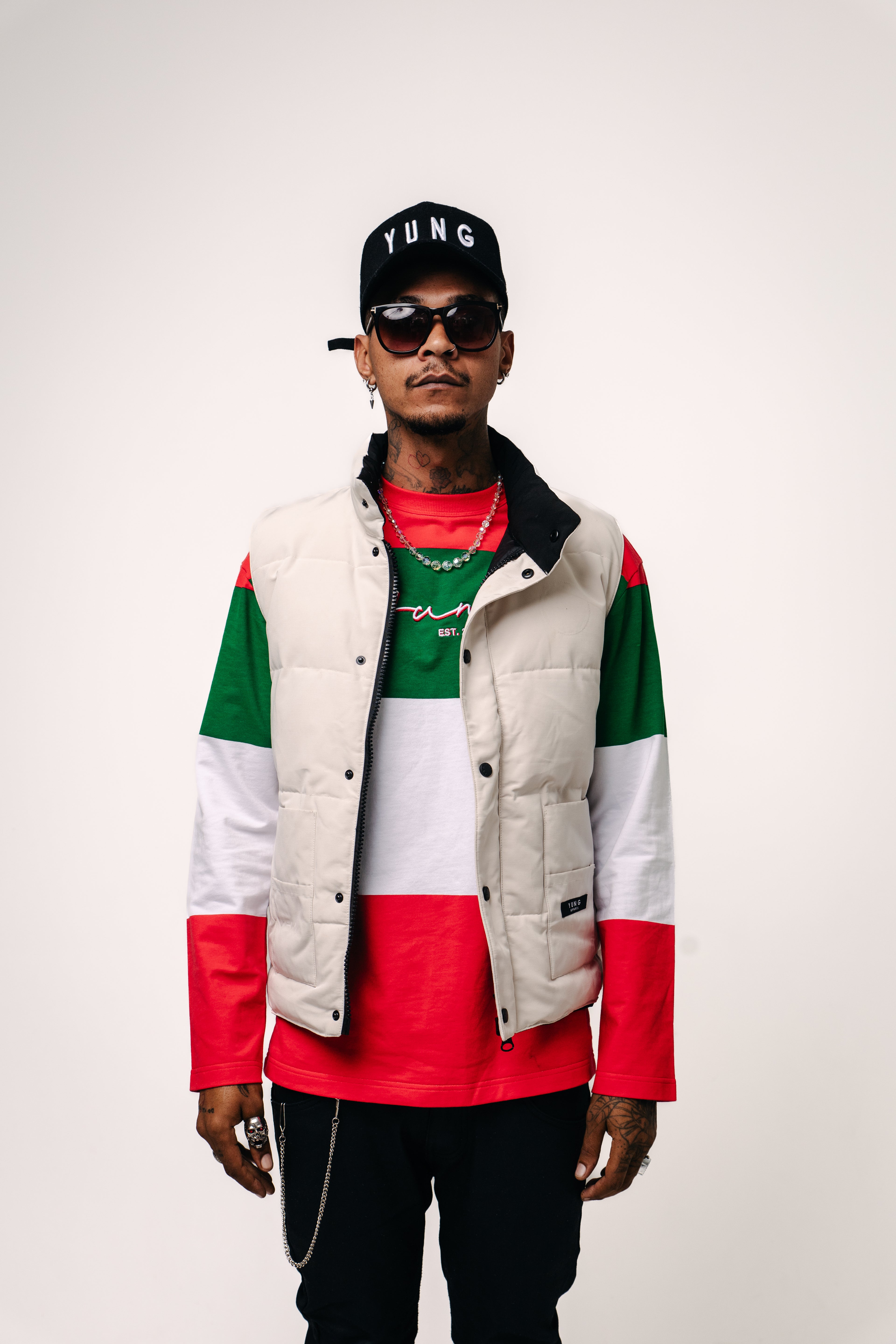 Person wearing a colorful jacket with red, green, and white accents on a plain background
Streetwear South Africa