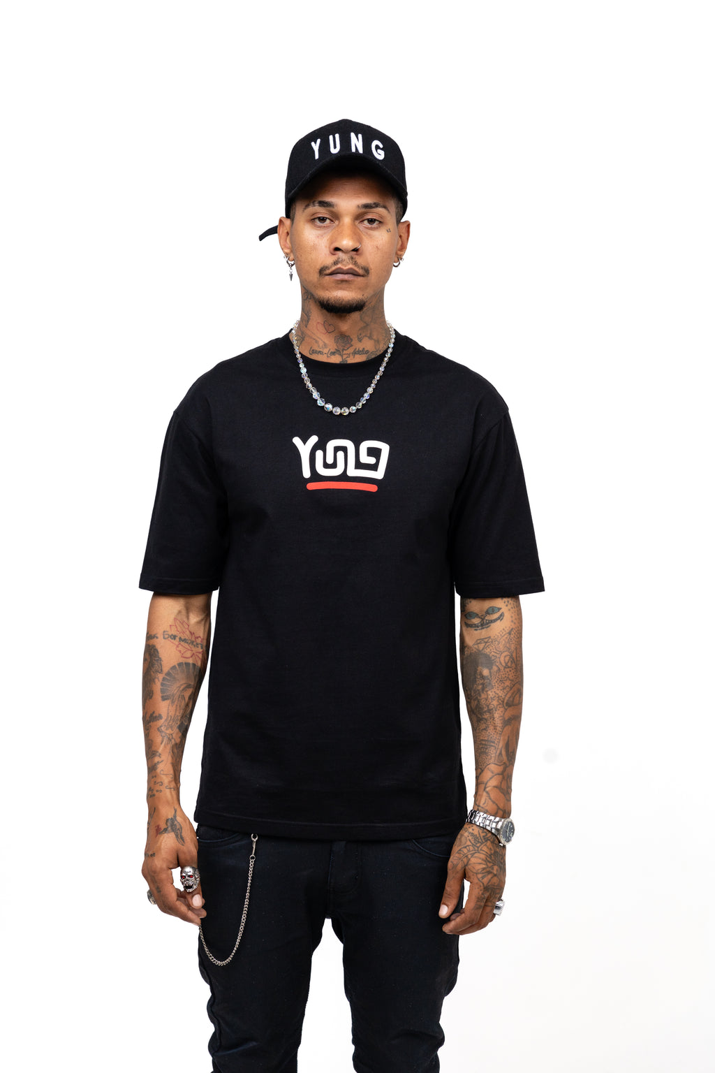 Man wearing a black t-shirt with a  Y U N Glogo and text, black pants, and a black cap with 'YUNG' on a white background.
Streetwear South Africa