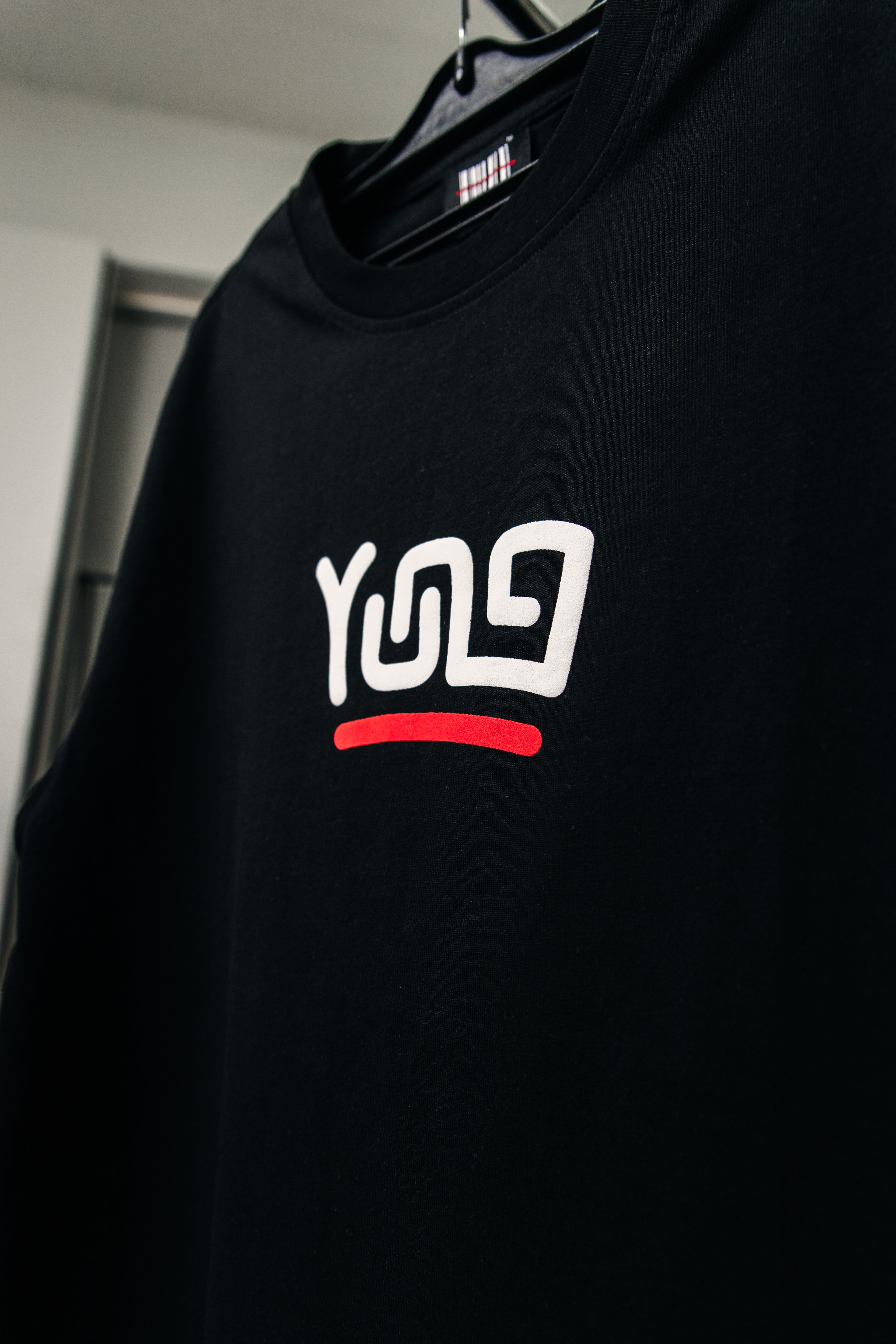 Y U N G Black t-shirt with a white and red logo on a hanger
Streetwear South Africa