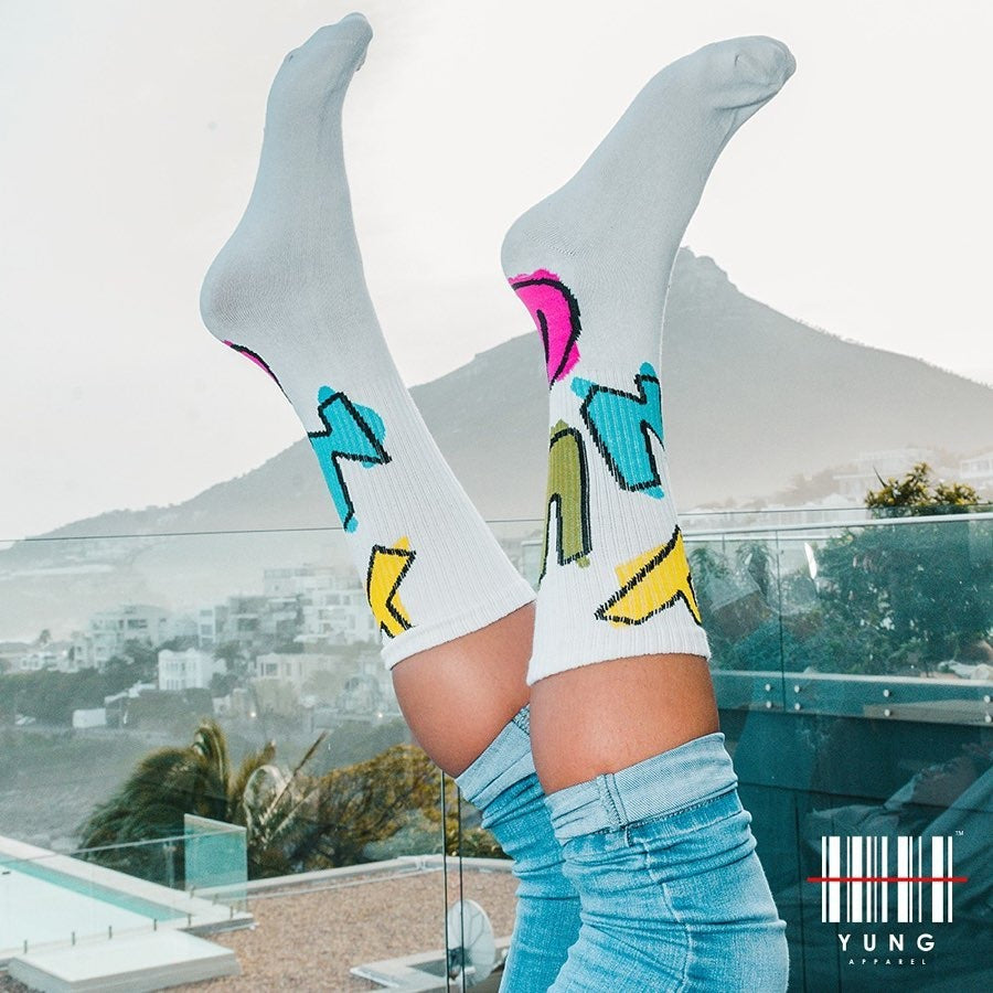 Person wearing Y U N G colorful socks with abstract designs in a scenic outdoor setting.
Streetwear South Africa