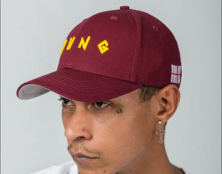 Person wearing a Y U N G maroon cap with yellow text on a plain background
Streetwear South Africa